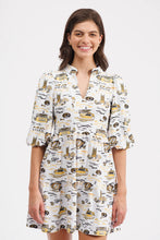 Load image into Gallery viewer, A woman modeling a white short-sleeve mini dress with a yellow and black illustrated pattern, set against a plain light gray studio background.
