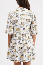 Load image into Gallery viewer, A woman shown from the back wearing a short puff-sleeve dress with a white base and an all-over print against a white backdrop.
