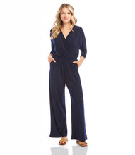 Load image into Gallery viewer, Our best-selling jumpsuit is now available in a beautiful navy color! Crafted from a high-quality, wrinkle-resistant jersey fabric, this jumpsuit is as low-maintenance as it is chic. Designed for the modern jetsetter, this jumpsuit combines comfort, style, and practicality for a seamless travel experience.
