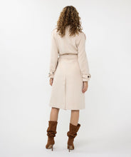 Load image into Gallery viewer, Classic, chic, and timeless, this stunning EsQualo Trenchcoat in a beautiful bisquit color is a must-have. The chic long trench coat features a bow belt and beautiful button details on the hem, sleeves, and shoulders, making it a perfect blend of elegance and sophistication.
