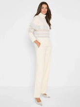 Load image into Gallery viewer, Woman wearing a cream and blue fringe detailed turtleneck sweater, cream pants and silver heels against a white background.
