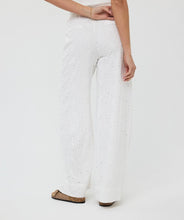 Load image into Gallery viewer, Step into elegance with the Tania Trousers by EsQualo, where soft off-white tones and delicate floral embroidery create a look that’s both timeless and fresh. Designed to flatter with a straight-leg silhouette and clean front closure, these trousers bring femininity to the everyday—perfect for garden brunches, summer soirées, or styled into fall with cozy knits and boots.
