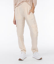 Load image into Gallery viewer, Experience ultimate comfort with our light sand colored cargo pants featuring an elastic waist band. The fabric is cool to the touch, ensuring a comfortable and stylish look. Dress up with wedges or heels or create a casual vibe with a pair of sneakers. You will absolutely love the feel of these Tana trousers.
