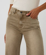 Load image into Gallery viewer, Close up of model wearing a white top and light caramel faded jean against a white background.

