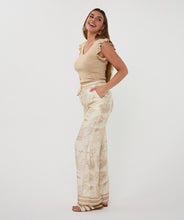 Load image into Gallery viewer, Woman in a beige sleeveless top and white and beige safari pants standing against a white background.

