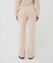 Load image into Gallery viewer, Model wearing beige pants against a white background.
