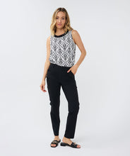 Load image into Gallery viewer, This black and white top features an elegant sleeveless design with a delicate bow at the back and beaded neckline. Perfect for wearing on its own or layering with a jacket or blazer. Experience the timeless chic of an ikat print with this stunning top.
