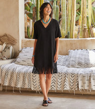 Load image into Gallery viewer, A basic black dress has been elevated to new heights with a lush curtain of fringe details at the hem. This comfortable dress is cut from stretch jersey-knit and can easily transition from brunch to dinner with a simple switch of shoes and accessories. Color - Black. Short sleeves. V-neckline. Fringe hemline. Fabric -90% Rayon. 10% Spandex.
