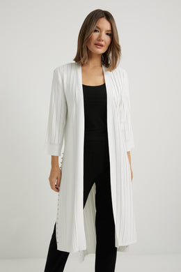 Whether you are getting ready for work or getting ready to meet friends for lunch, this fabulous cardigan with its long, drapey silhouette and side slits is the perfect choice.  The design by Joseph Ribkoff is a lightweight cardigan that will elevate a look while keeping you warm in the air-conditioned climates. Not your ordinary cardigan, our Terra has an updated modern look thanks to the subtle yet striking studs lining the split sides. Color- Vanilla. Drape silhouette. No pockets. No zipper. Not lined.
