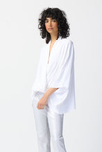 Load image into Gallery viewer, Our woven wrap top is a must-have garment that exudes confidence and grace. With dolman sleeves and a pleat detail at the neck, this top brings versatile style to your wardrobe, draping gracefully to flatter every body type.  Color- Vanilla. Woven fabric. Wrap neckline. Dolman sleeves. Pleated detail at the neck. Unlined.
