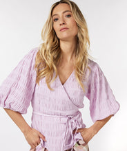 Load image into Gallery viewer, Equalize your fashion game with this stylish seersucker blouse in a show stopping violet. The wrap style and billowy elasticized elbow sleeves are perfect for creating a flattering silhouette. With its modern look and timeless quality, you&#39;ll be turning heads for seasons to come.
