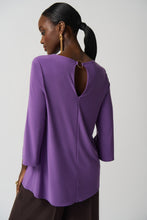 Load image into Gallery viewer, This stunning tunic designed by Joseph Ribkoff offers a graceful fit and an eye-catching look, with a vivid violet hue and a silver-ring keyhole detail on both the front and the back. Its effortless style ensures that it will be a statement piece in your wardrobe.  Color- Violet. Tunic length. Keyhole design. Silver ring hardware in front and back. Fabric- 96% Polyester. 4% Spandex.

