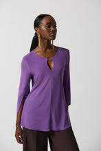 Load image into Gallery viewer, This stunning tunic designed by Joseph Ribkoff offers a graceful fit and an eye-catching look, with a vivid violet hue and a silver-ring keyhole detail on both the front and the back. Its effortless style ensures that it will be a statement piece in your wardrobe.  Color- Violet. Tunic length. Keyhole design. Silver ring hardware in front and back. Fabric- 96% Polyester. 4% Spandex.

