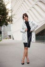 Load image into Gallery viewer, You&#39;ll stay cozy warm when temperatures drop while feeling effortlessly stylish in this unique cardigan with a black dot pattern on a white background. The open front sweater cardigan provides a great opportunity to create an array of fashionable looks, like teaming it with a black top and denim for a laid-back chic ensemble or darker bottoms, skirt or dress for a more elevated look.  Color- White with black dots. Open front. Fuzzy sweater knit. Collared. Front slit functional pockets.
