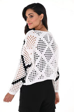 Load image into Gallery viewer, Crafted with a combination of intricate texture and subtle sparkle, this Bria Black and White Open Stitch Sweater by Frank Lyman offers a chic and modern twist on traditional knitwear. The striking contrast black and white print is highlighted with strategically placed sparkling rhinestones.&nbsp; Its versatile design seamlessly transitions from casual daytime wear to elegant evening attire, adding a touch of sophistication to any ensemble. This fabulous top is striking when worn over a black or white tank.
