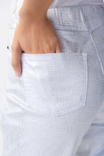 Load image into Gallery viewer, These high-quality denim jeans feature a classic and elegant design with a shimmering foil animal print. The slim crop silhouette provides versatility, while the hidden elastic waistband ensures comfort and security.  Color- White and silver. Foiled twill. Hidden elastic waistband. Two back pockets. Unlined.
