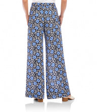 Load image into Gallery viewer, Woman wearing blue floral wide-leg pants and white sandals on a white background.
