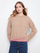 Load image into Gallery viewer, A woman wearing a beige crewneck sweater with bright pink contrast stitching and a pink hem, paired with blue jeans, against a plain white background.
