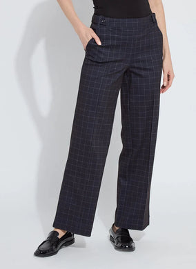 Model wearing dark plaid pants and black loafers against a white background.