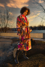 Load image into Gallery viewer, triking beauty describes this long ultra-fashionable coat with an abstract pattern design.  Two color choices for you to choose from.  Anthracite, which is a fuchsia, camel, brown and anthracite and Cream which is burnt orange, grown, tan, olive and off-white. Be the center of attention when you wear this amazing piece of art.  Colors- Cream multi or Anthracite multi. One button closure. Self-front tie. Belt design on cuffs Functional side pockets. Fabric- 100% Polyester.
