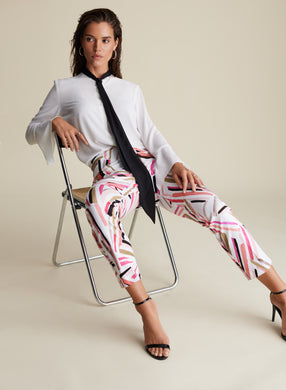 How stunning is this Lydia pant by Joseph Ribkoff?  A unique blend of abstract stripes in colors of pink, peach, black and taupe playfully sit on a white background.  A gorgeous slimming, stretch fit allows for easy movement and comfort that will last throughout the day.  Pair with a solid black or white top to create a fashionable look that will get you noticed!