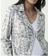 Load image into Gallery viewer, How fabulous is this Ranya Moto Letter Jacket in vegan leather?  A true statement piece designed by the fabulous Joseph Ribkoff; this jacket will create an edge to an outfit. Colors of champagne with silver detailing and gray lettering is definitely an attention getter! The fabrication is so very soft. The Ranya features a faux zipper, a clasp for closure, subtle shoulder pads, exposed zipper pockets and cropped fitted silhouette.  Colors- Champagne with gray lettering. Silver hardware.
