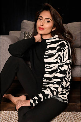 Black and white contrast with half zebra pattern, creates a chic and sophisticated sweater by Frank Lyman.  This modish style pairs beautifully with almost any bottom. Prepare to receive many compliments when you wear this cozy, fashionable sweater.  Color- Black and white. Half solid, half zebra print. High neck. Pull-over. Cozy.