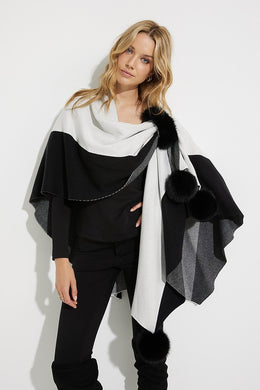Striking and elegant, our Joseph Ribkoff poncho is the perfect cool weather wardrobe piece.  The gorgeous two-tone fabrication and faux fur pom pom details create a look that is uniquely beautiful and chic. Simply slide one side through the faux fur loop to easily hold the poncho in place and create a chic look. You will certainly make a dramatic entrance when you wear our cozy Tamara poncho. Color- Black and vanilla. Wrap around poncho. Faux fur pom poms and faux fur loop. No pockets.