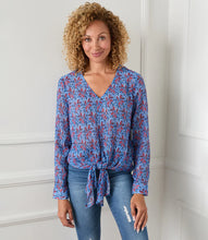 Load image into Gallery viewer, Various floral and shapes print in colorful blue and red hues brings this figure flattering tie front top to life. The addition of shimmering metallic lurex makes it the perfect way to dress up any outfit. Color- Red and blue. Long sleeve button cuff. V-neck. Tie-front.
