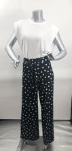 Load image into Gallery viewer, Create a fashionable look with our black and white polka dot pant designed by Frank Lyman.  A perfect pant for the summer season, just pair it with one of our white or black tops and you will be a fashionista ready to seize the day.  A perfect pant to travel with as it does not wrinkle!
