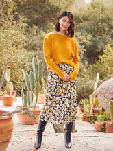 Load image into Gallery viewer, Add a romantic feature to your wardrobe with this floral garden print midi skirt. Our Gia skirt is designed with an easy pull-on silhouette that flows away from the body in streamlined sophistication. For a gorgeous look, pair with our GEORGIA GOLD SATIN LONG SLEEVE BUTTON DOWN SHIRT. Color- Black, white and gold. Floral print Elasticized waistband. Bias cut. Mid-rise Floral print
