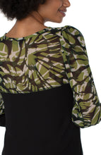 Load image into Gallery viewer, Our Kacie knit top, with floral woven sleeves, transitions effortlessly from season to season. This mixed media top looks beautiful when worn with denim or a pair of your favorite black pants.  Color-Abstract foliage- Black, olive green and white. Woven sleeves. Woven detailing on the back. Foliage trim at the neckline.
