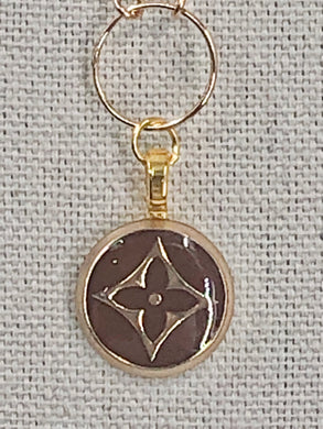 Nothing is more elegant than simplicity, and our Lenora necklace is definitely elegant.  The iconic gold LV symbol pops on the brown background of this vintage button pendant.  Add a shiny gold, dainty chain with a round finding and you have a timeless necklace that will elevate any outfit.