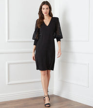 Load image into Gallery viewer, This stunning black dress is elevated to a whole new level with beautiful airy lace sleeves. This curve-defining dress is cut from soft jersey-knit for a comfortable, evening look. Pair with tall black boots or your favorite pair of heels. Color- Black. Blouson lace sleeve. Center back invisible zipper. Sheath silhouette. V-Neck.

