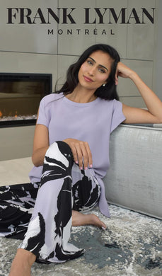 Elevate your wardrobe with the Frank Lyman 181224 Iris Side Tie Top, a stunning piece in a light lavender hue that exudes effortless elegance. Designed with a flattering side tie, this top creates a beautifully draped silhouette that enhances your shape while adding a touch of sophistication. The split cap sleeves provide a breezy, modern look, making it perfect for both casual and dressy occasions.