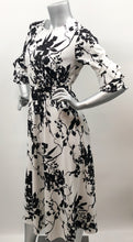 Load image into Gallery viewer, Every fabulous woman needs a black and white dress to showcase her beauty and our Vivien Black and White Floral Mid Length Dress by Papillon is the perfect dress to do just that.  Whether you are going to a garden party, a wedding or a lovely dinner, this dress will make you feel like royalty.   Colors- Black and White floral. Tie waist belt. Mid length.
