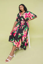 Load image into Gallery viewer, The Ellie Woven Maxi Dress is so stunning with a black background and a floral print that just pops!  This gorgeous style features a surplice neckline and is a true wrap design with a ruffled hemline. A dress for those perfect moments in your life.

