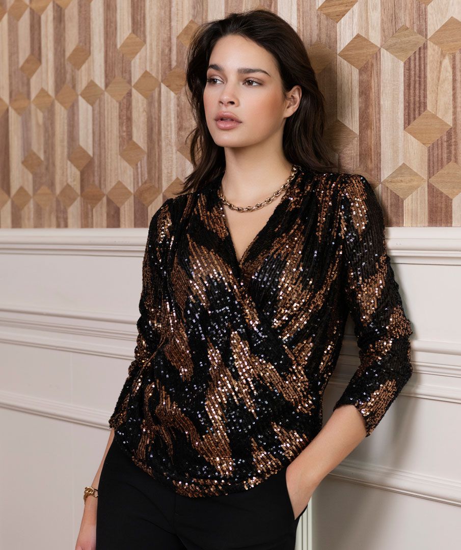 Shine and sparkle at your next event with this stunning sequin wrap over top. Just the perfect amount of stretch creates a comfortable fit.  A beautiful style, our Sabine pairs perfectly with black pants. Combine with a pair of black faux leather pants and heels and you are party ready.  Color- Black and bronze. Wrap over style. V-neck. Fabric- 100% Polyester.