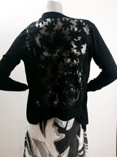 Load image into Gallery viewer, Not your ordinary cardigan, this delightful lightweight cardigan is one that you will wear again and again.  With its sheer black back and shoulder panels with black raised flowers, and a waterfall draping on each side, you are sure to receive compliments.  This black, long sleeve cardigan will elevate almost any dress or top in your closet.  Color-Black. Back and shoulder lace panels with raised floral pattern. Waterfall draping design on each side.
