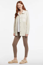 Load image into Gallery viewer, This gorgeous, ultra-soft vegan leather jacket in natural, is a timeless piece that pairs so well with almost anything in your closet. A button front closure, a classic shirt collar, and a curved shirttail hem add to the wonderful design. Look stylish, classy and modern when you wear this fabulous piece.  Color- Natural. Button front with shirt collar. Relaxed fit. 29&quot; length with curved shirttail hem. Chest pockets. Soft vegan leather. Fabric-Face 100% Polyurethane. Backing 100% Polyester.
