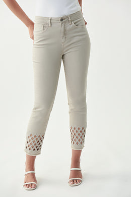 Pictures just do not do this gorgeous jean by Joseph Ribkoff justice!  A beautiful tan color fabric is enhanced with a sparkling lattice design in silver crystals mid-calf. Bottom of each leg is slightly frayed to give just the right amount of edge.  A stunning crop jean to dress up or wear casually.  Either way, you will be receiving compliments when you wear our Larisa!  Color-Denim Sand.  Silver buttons and hardware.  Silver crystals.