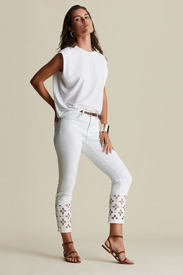 This slim leg capri designed by Joseph Ribkoff has a style that is not only unique but highly fashionable. The floral cut-out pattern at the cuff of each leg is enhanced by sparkling crystals that catch the eye! A slight fray at the bottom of each leg gives this spectacular jean an edge. The Isla is not only elegant but also fun at the same time.  A pure white jean, this capri will pair beautifully with anything in your closet!