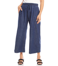 Load image into Gallery viewer, What is better than a pair of breezy, comfortable wide leg pant to keep you cool and comfortable during those warm, sunny days? Our Whitney Wide Leg Pant is just that, a breezy, roomy, Tencel cotton pant that features an elasticized waistband, functional front pockets and a front tie detail.  A versatile bottom to wear casually or dressed up. Color- Denim blue. Elasticized waistband. Ankle length.
