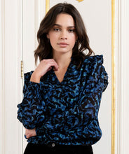 Load image into Gallery viewer, A gorgeous pop of all over blue in an animal print is striking on the Wilda Wild Celebration Blouse. The Wilda has a round neckline, decorative ruffles on the shoulders and smocked cuffs. Pair with a pair of faux leather or black pants or your favorite denim and boots and you&#39;ll be a fashionista!
